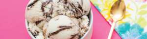 vanilla ice cream with chocolate variegate swirl on pink background with gold spoon